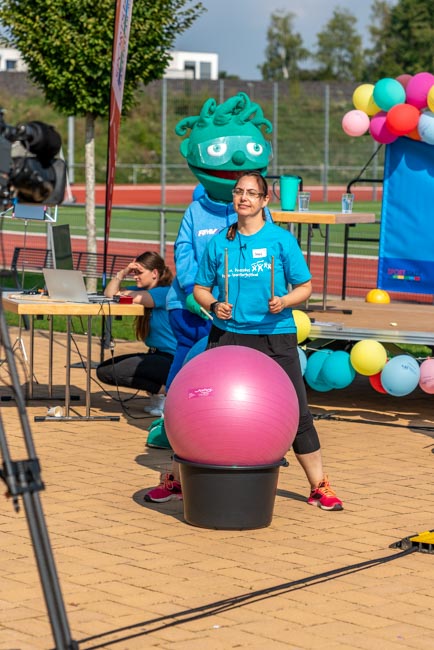 Foto: Kameramann filmt eine Person mit Drumsticks, die auf Gymnastikball trommelt.